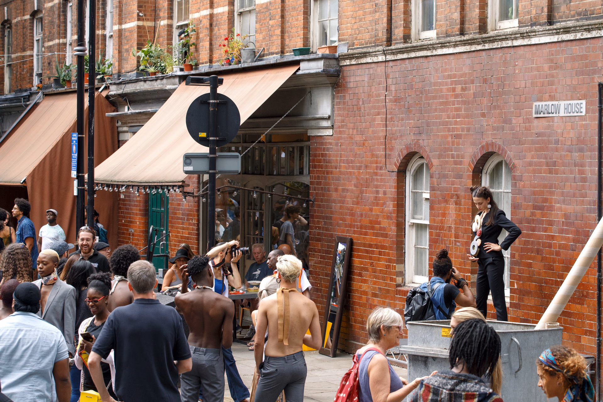 A model posing for photographers at a street style festival