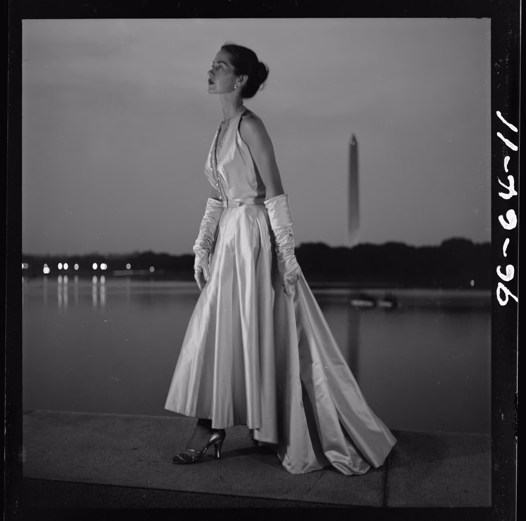 A model posed in an evening gown under studio light