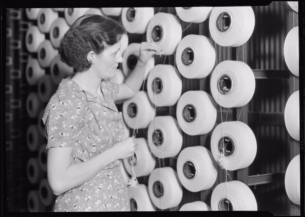 An archival black-and-white photograph of a woman at work