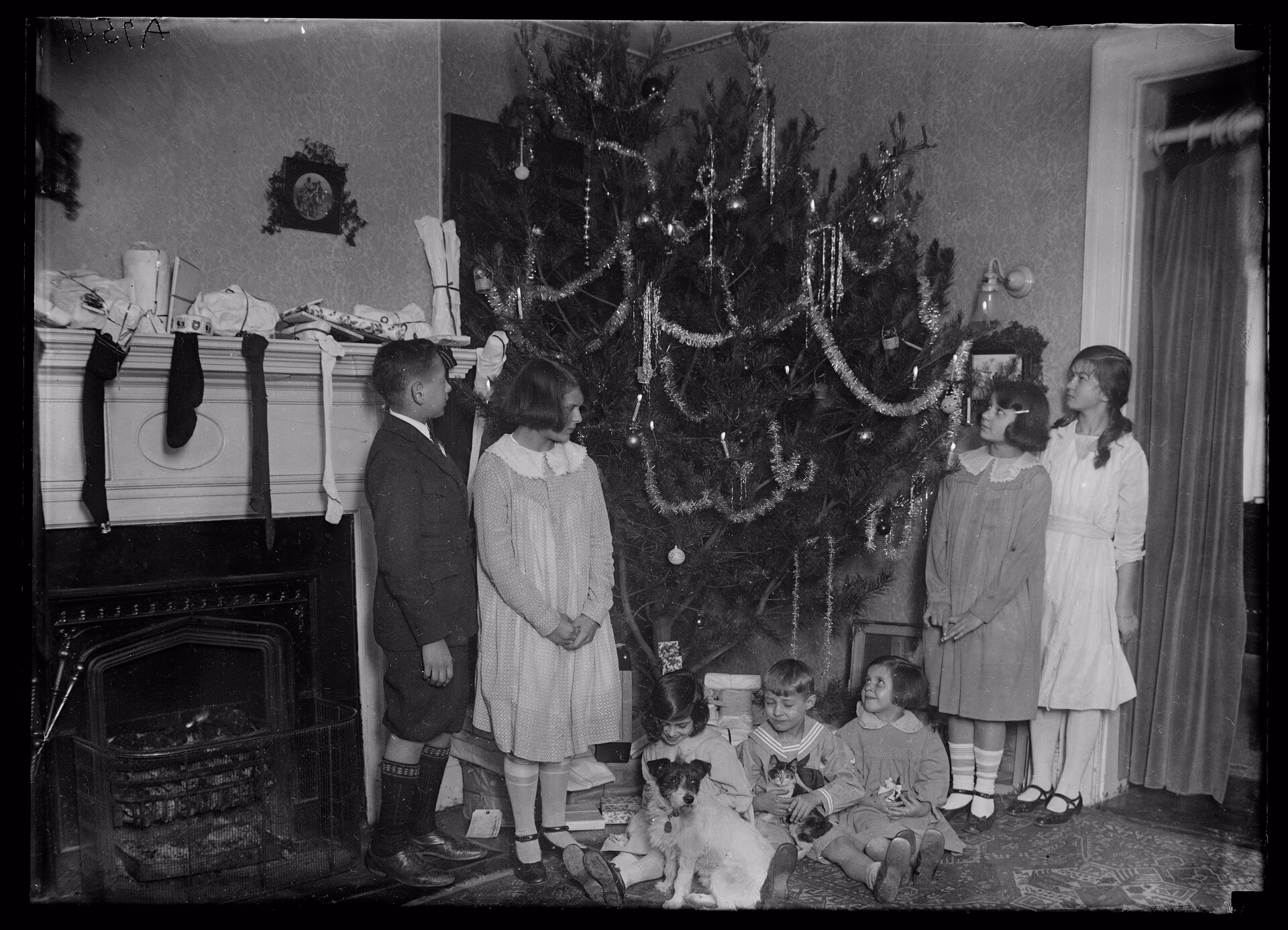 An archival photograph of a family gathered around a Christmas tree